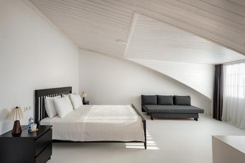 a white bedroom with a bed and a couch at Cedori Butik Otel in Ezine