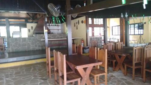 a restaurant with wooden tables and chairs in a room at Hotel Colonial in Piraí