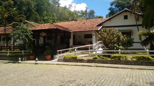 a house with a porch and a fence in front of it at Hotel Colonial in Piraí