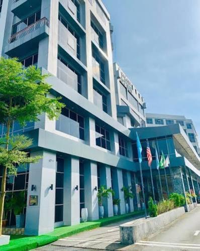 a tall building with a flag in front of it at Galaxy La Palm Royal Hotel in Port Harcourt