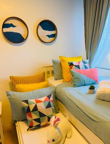 a room with two beds with pillows and a stuffed animal at Bienvenida Condotel in Dumaguete