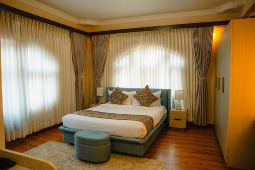 a bedroom with a large bed in front of windows at Devi Aura Villa in Burhānilkantha
