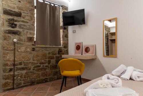 ein Zimmer mit einem Tisch und einem gelben Stuhl in der Unterkunft Da Concy in Castelmezzano