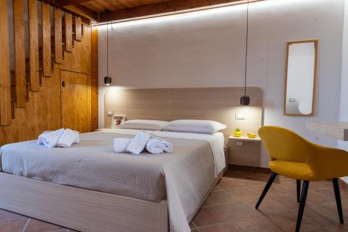 ein Schlafzimmer mit einem Bett und einem gelben Stuhl in der Unterkunft Da Concy in Castelmezzano
