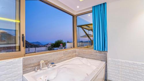 a bath tub in a bathroom with a large window at Secluded Sea-View Romantic Escape Villa Bella 4 Leylak in Üzümlü