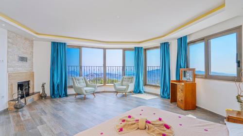 a bedroom with blue curtains and a room with a fireplace at Luxury Valley-View Escape in Islamlar -Villa 5 Kartal Yuvası in Üzümlü