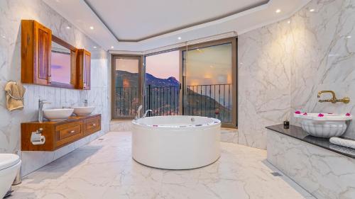 a bathroom with a tub and two sinks and a window at Luxury Valley-View Escape in Islamlar -Villa 5 Kartal Yuvası in Üzümlü