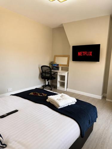 a bedroom with a bed and a desk with a chair at Wellingborough Luxury Staycation 3 Bed 2 Bath in Wellingborough