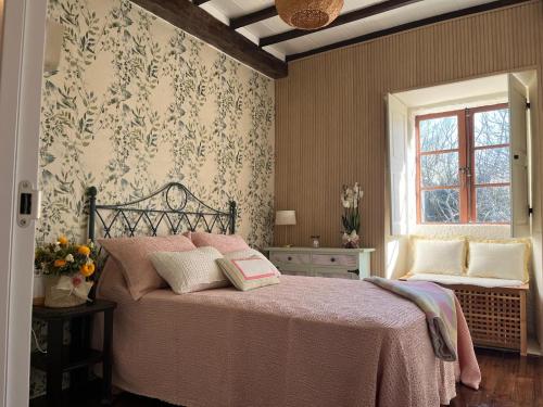 a bedroom with a bed with pink sheets and a window at La minada in Covelo