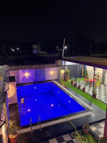 a large swimming pool at night with lights at lavender hill in Jaipur