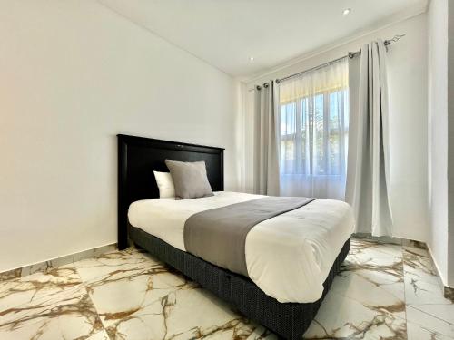 a bedroom with a large bed and a window at Number 15 Jadde Apartments in Sandton