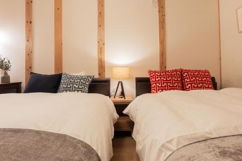 two beds sitting next to each other in a room at Cove琴平 - 1組貸切 最大8名 こんぴらさん徒歩すぐ in Kotohira