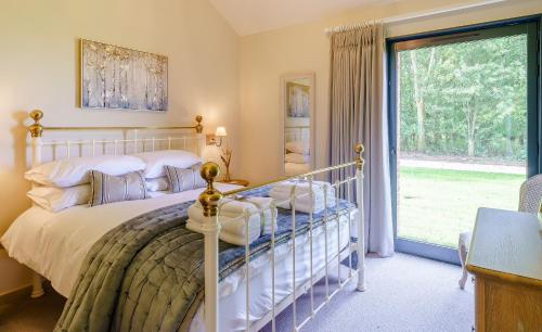 ein Schlafzimmer mit einem Bett und einem großen Fenster in der Unterkunft 1 Pheasant in East Ilsley