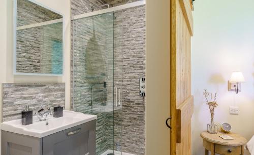 ein Badezimmer mit Waschbecken und Glasdusche in der Unterkunft 1 Pheasant in East Ilsley