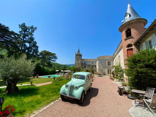 an old car parked in front of a building at Château des Janroux in Juliénas