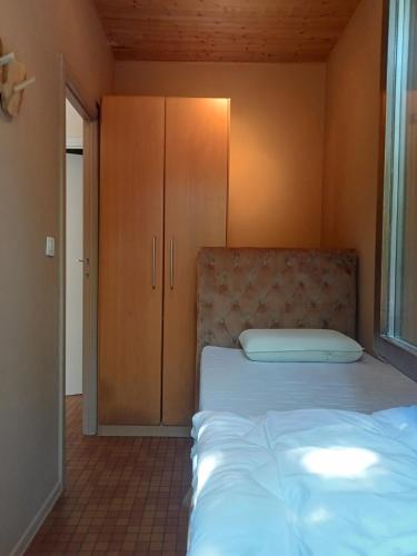 a bedroom with a bed and a cabinet at La petite maison 34 in Waulsort
