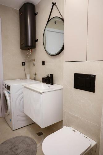 a bathroom with a washing machine and a mirror at Azure Sunset in Donja Lastva