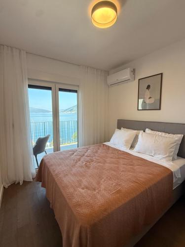 a bedroom with a bed with a view of the ocean at Azure Sunset in Donja Lastva