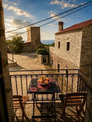 a table with a bowl of fruit on a balcony at Diaks Tower Sunset Sea View Mani in Pyrgos Dirou