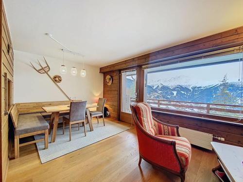 a dining room with a table and chairs and a large window at Tayannes 222 in Verbier