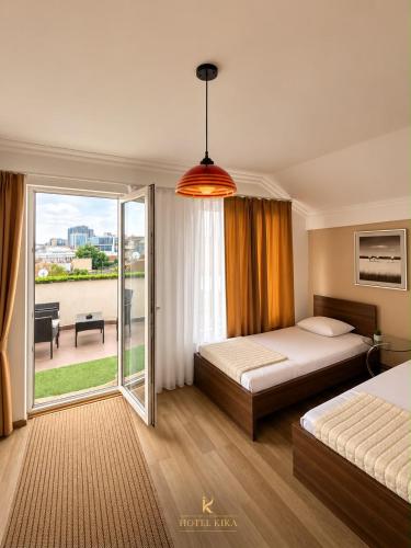 a hotel room with a bed and a balcony at Hotel Kika in Prishtinë