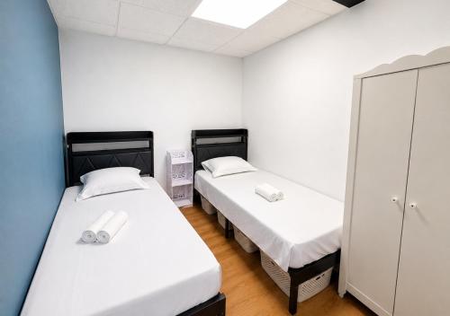 two beds in a room with white walls at Grand T4 Compiègne in Compiègne