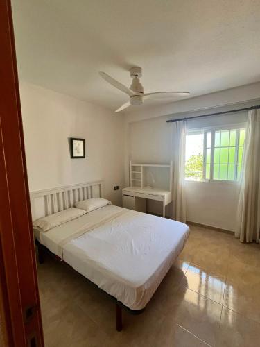a bedroom with a bed with a ceiling fan at Bacarola in Los Mártires
