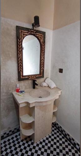 a bathroom with a sink and a mirror at Riad Kasbah Le Touareg in Merzouga