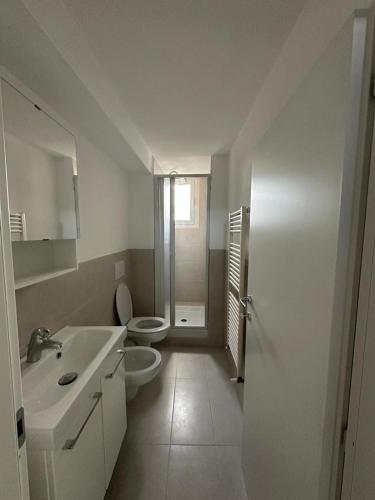 a white bathroom with a toilet and a sink at Cozy Apartment in Chieti Centro in Chieti
