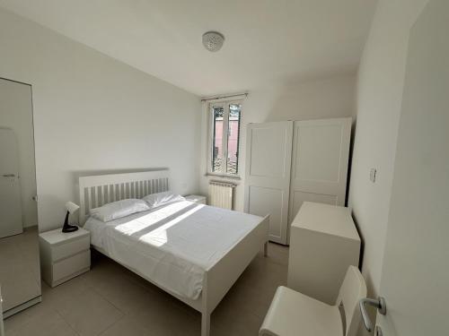 a white bedroom with a bed and a window at Cozy Apartment in Chieti Centro in Chieti
