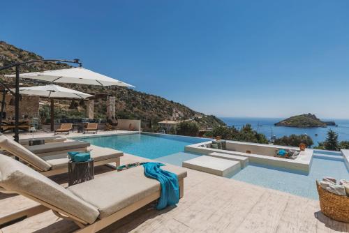 a swimming pool with lounge chairs and a view of the ocean at Apaggio Luxury Villa - Private Pool & Stunning Sea Views, by ZanteWize in Agios Nikolaos