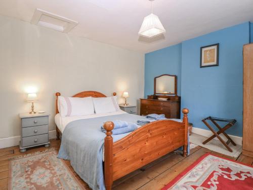 a bedroom with a bed with blue walls and a television at The Lock House in Gloucester