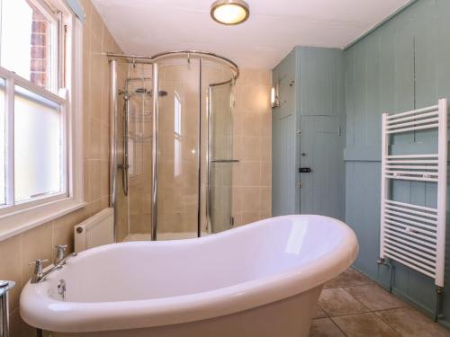 a white bath tub in a bathroom with a shower at The Lock House in Gloucester
