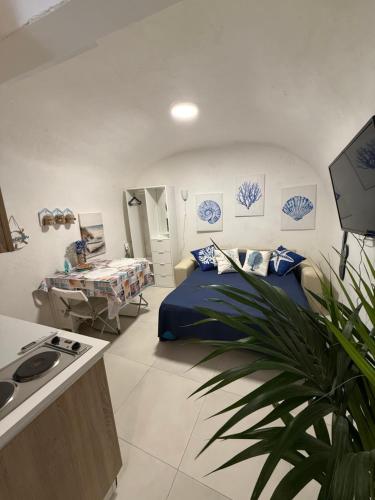 a bedroom with a bed and a table and a plant at Maja cuore blu in Vieste
