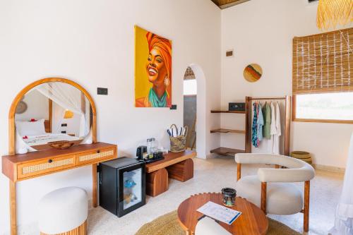 a living room with a table and a mirror at Casa Rodi Zanzibar in Jambiani