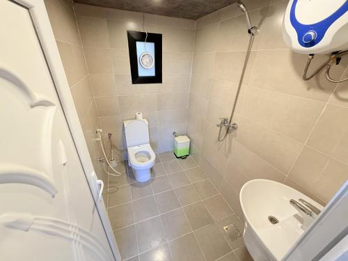 a small bathroom with a toilet and a sink at Neem camp in Nizwa