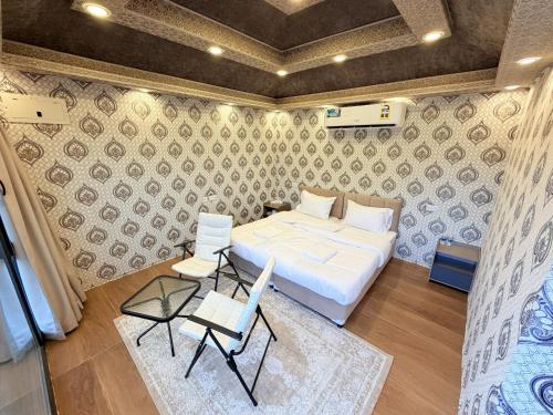 a bedroom with a bed and a table and chairs at Neem camp in Nizwa
