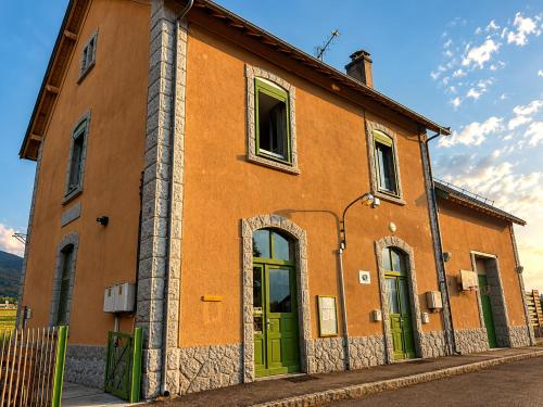 an orange building with green doors on a street at L'auberge de la Ludogare in Saillagouse