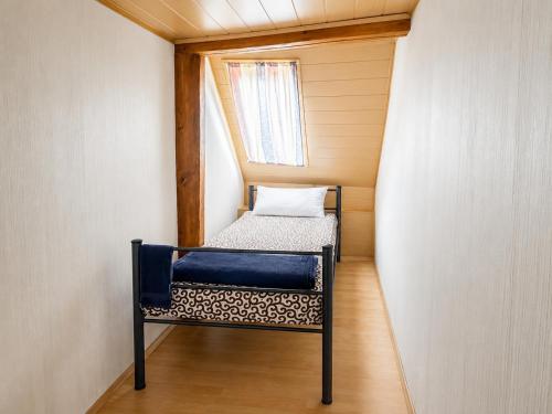 a small bed in a small room with a window at Workers House in Bockenem