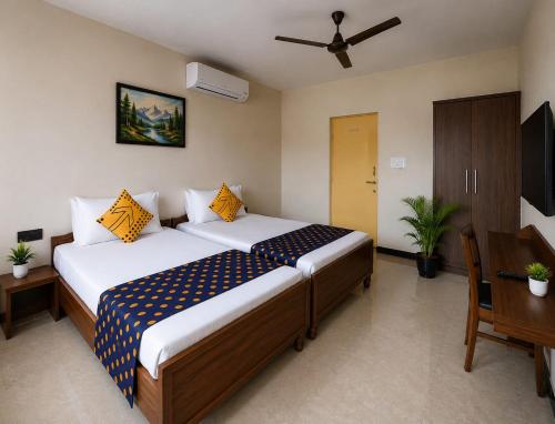 a hotel room with a bed and a desk and a bed at Hotel Shepherds in Bīdar
