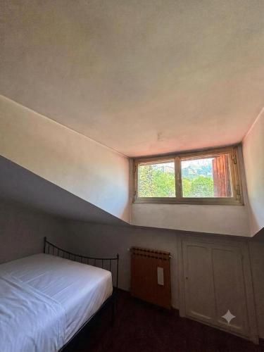 a small bedroom with a bed and a window at La Mansarda del Vecchio Mulino in Entracque