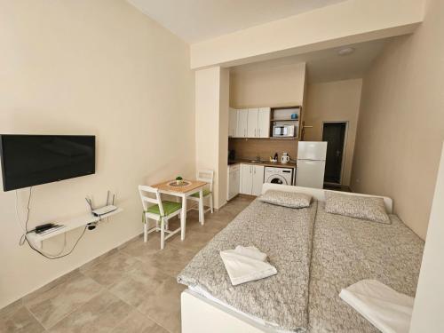 a bedroom with a large bed and a kitchen at Апартаменти Кастро2-Castro Apartments2 in Tsarevo