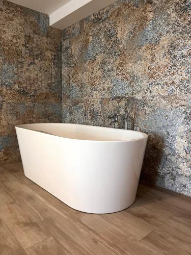 a white bath tub in a room with a wall at Prenoćište Nikolić in Negotin
