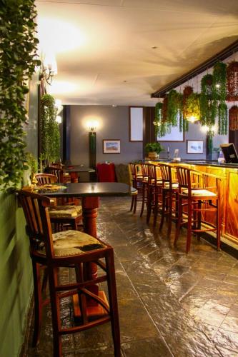 a bar with wooden tables and chairs in a restaurant at Platrand Lodge in Ladysmith