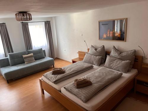 a bedroom with a large bed and a couch at Ferienwohnung am Reichenbach in Hechingen