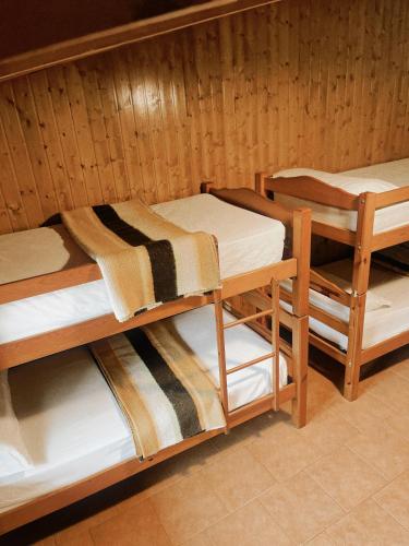 two bunk beds in a room with wooden walls at Alberg rural torre del baró in Sant Llorenç de Morunys