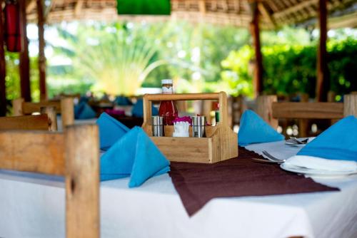 a table in a restaurant with blue napkins and a table set up at Balungi Boutique Hotel in Uroa