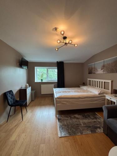 a bedroom with a bed and a chair and a window at Pas Kastyti in Palanga