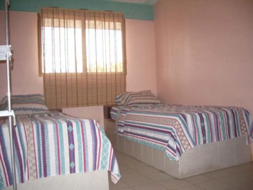 a bedroom with two beds and a window at Romervic vacational apartments in Juangriego