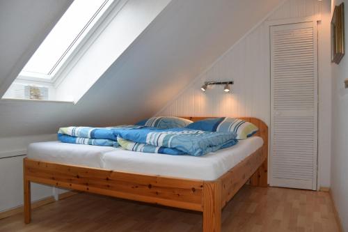 a bedroom with a bed with blue pillows on it at Wichmann, Ursula & Axel in Schönberg